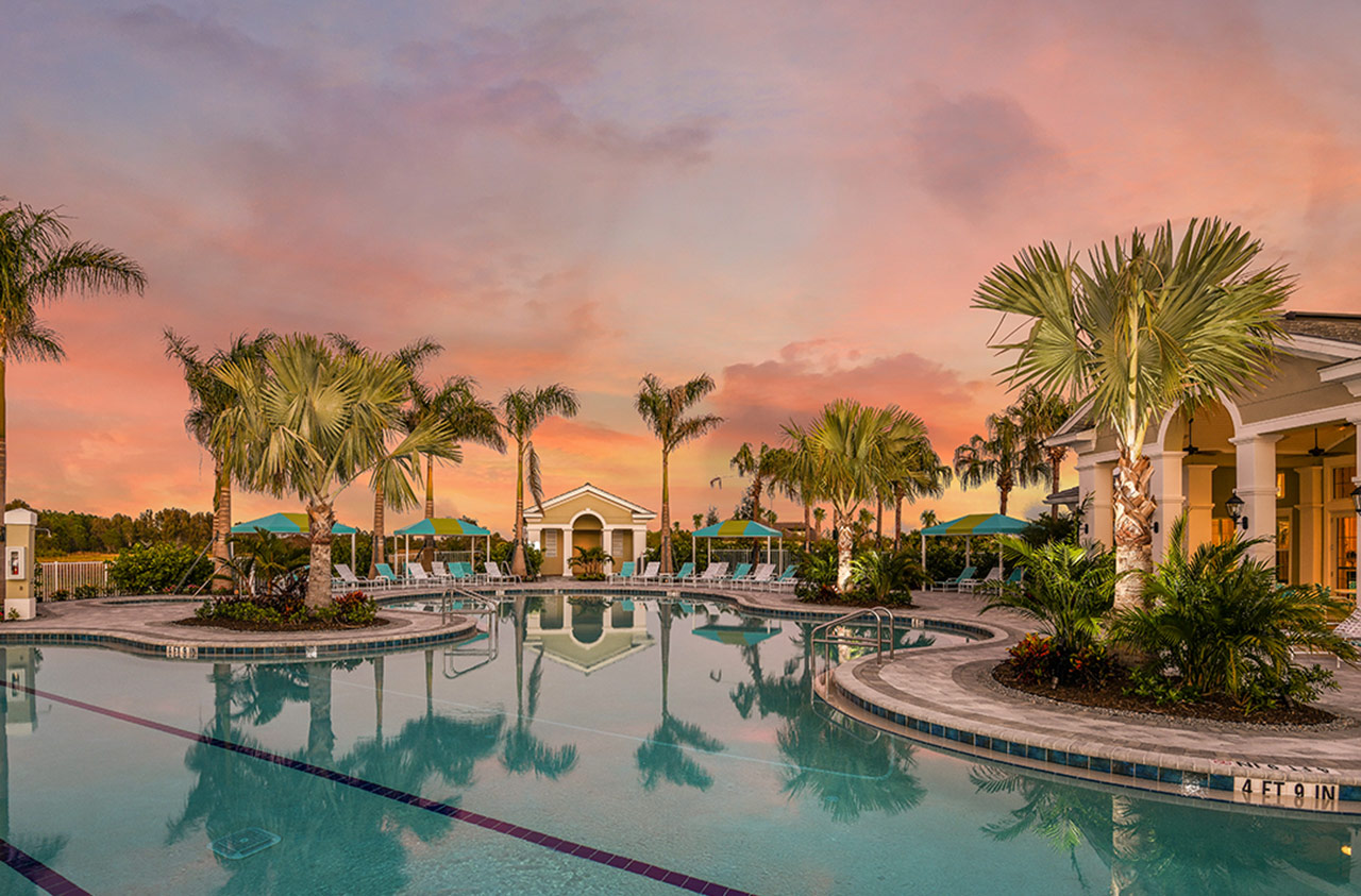 Resort pool at Boca Royale at sunset with palm reflections and tropical cabanas
